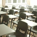 Rows of empty classroom desks and seats.