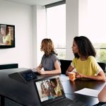 A small group of employees in a collaborative workspace utilizing video conferencing technology.