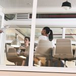 Image is of three people in a corporate office location.