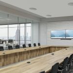 A large conference room with in-ceiling speakers and Crestron displays.