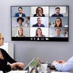 A team in a conference room uses technology during a meeting.