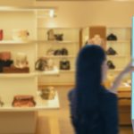 Retail store showcasing a digital signage display with personalized offers for handbags, set against shelves of luxury bags in a brightly lit environment.